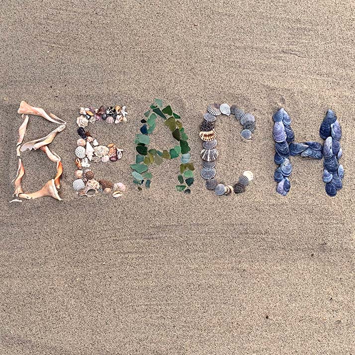 Sea glass and shells spelling out 'BEACH'