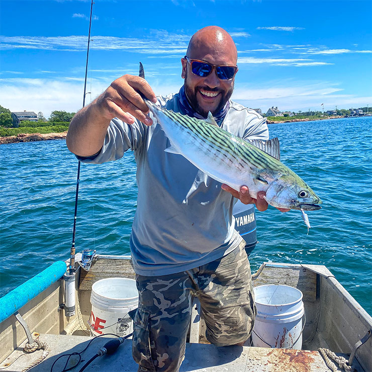 Aaron holding a fish on a boat