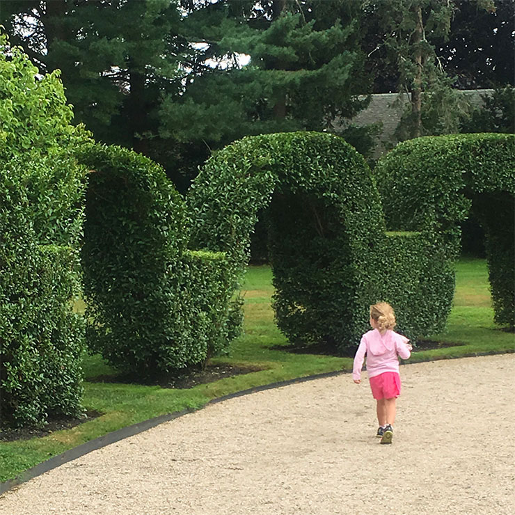 Little girl walking through a garden
