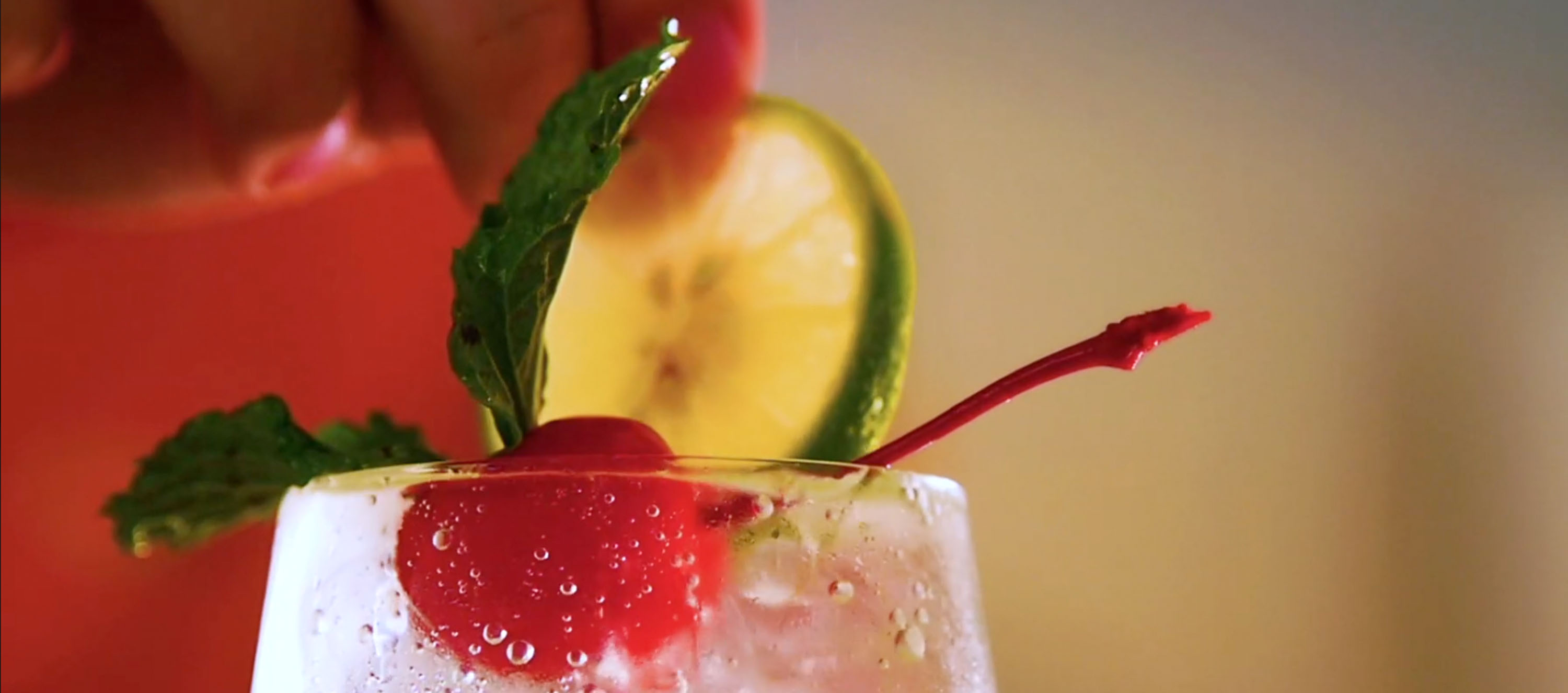 person adding a lime to garnish a drink