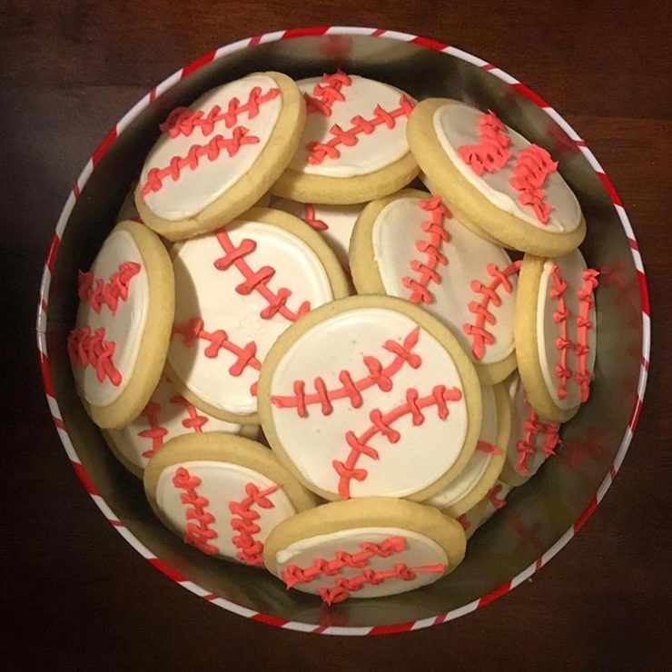 tin of cookies decorated as baseballs