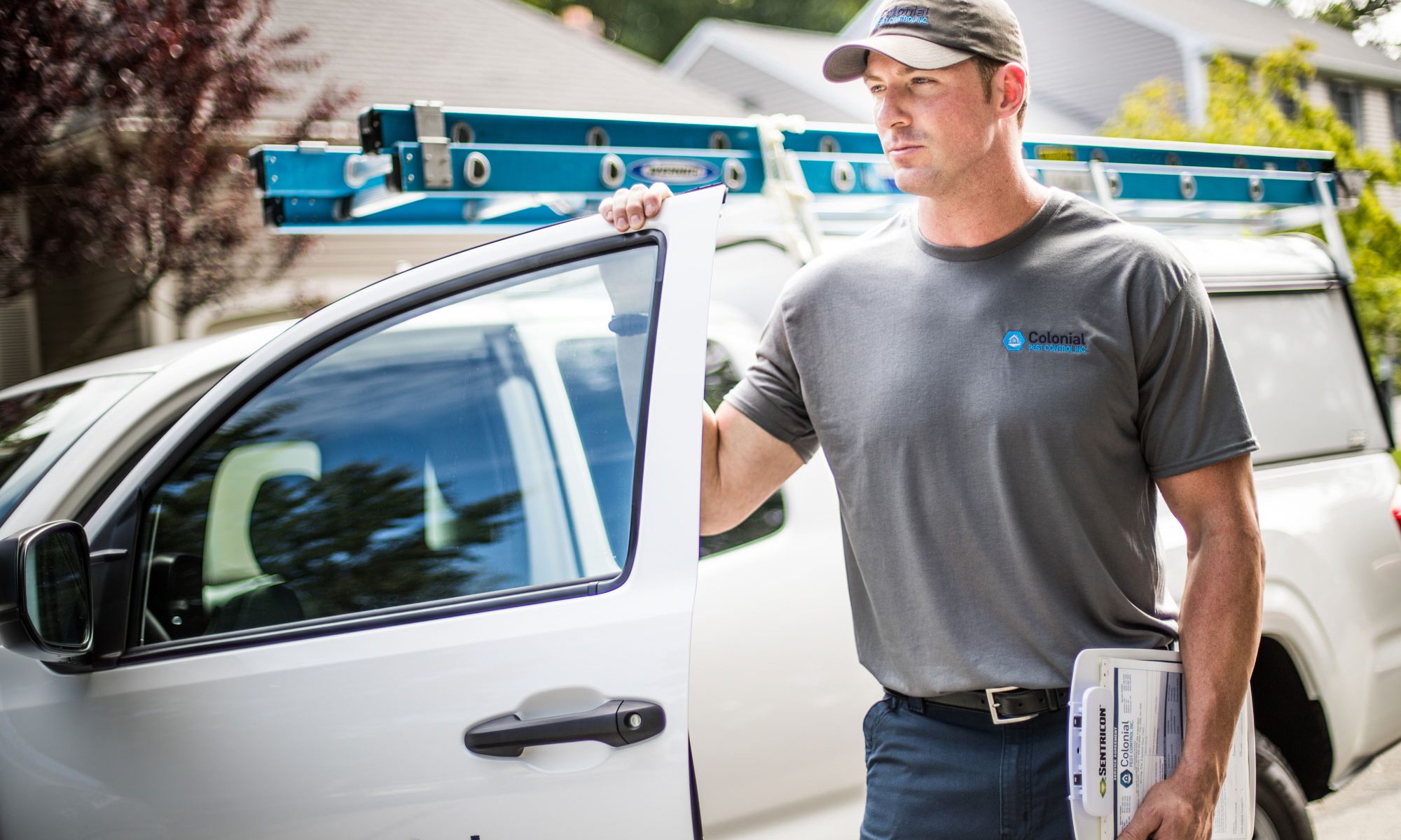 colonial pest employee standing next to the work truck