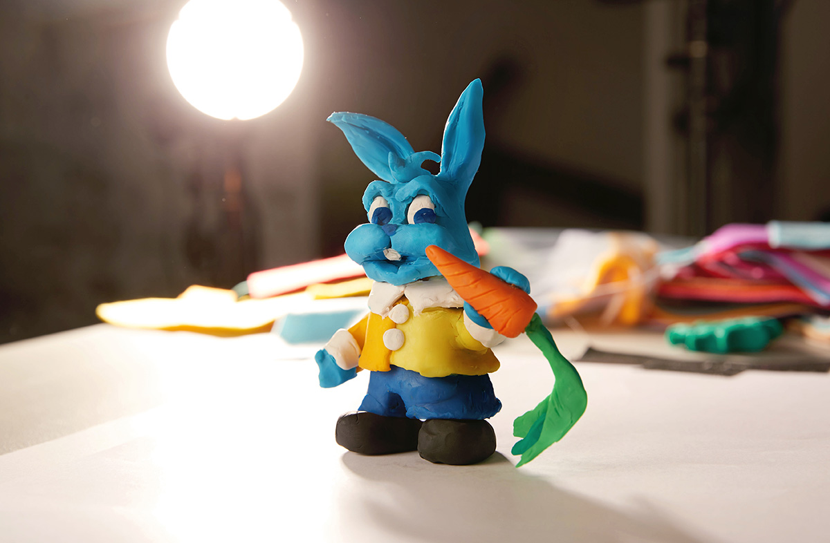 blue clay rabbit holding a carrot