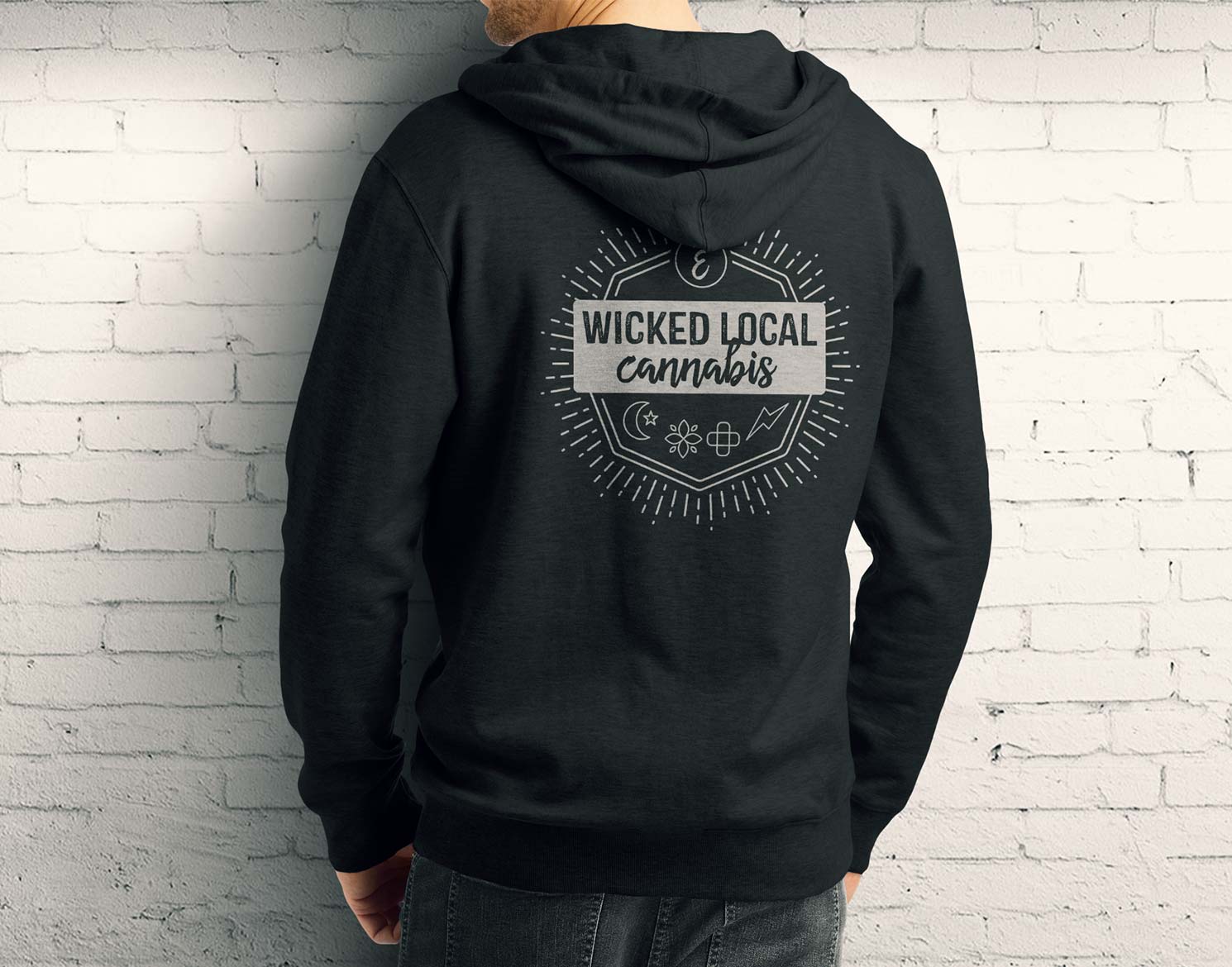 man wearing an Ermont sweatshirt with artwork on back that says "Wicked Local Cannabis"