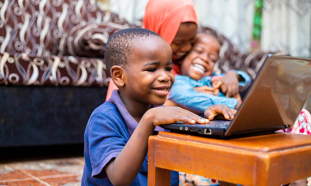 young child in impoverished country learning on a laptop