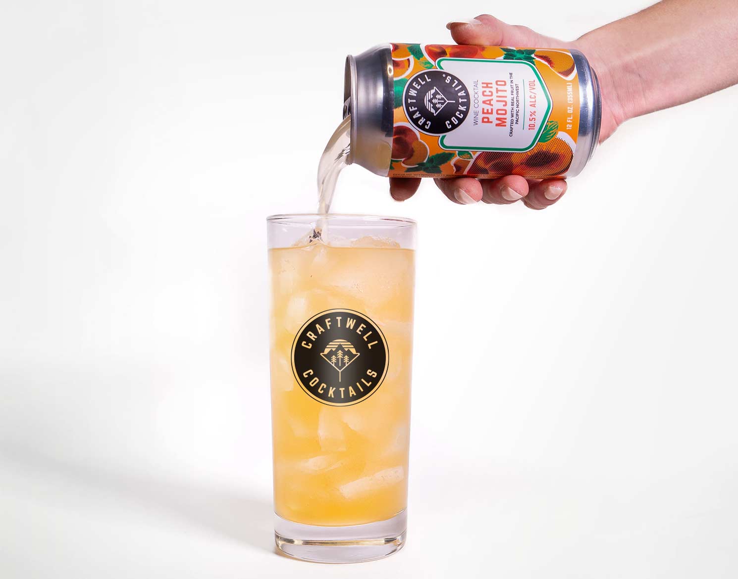 Craftwell Cocktail's peach mojito can being poured into a tall glass with the Craftwell Cocktail logo