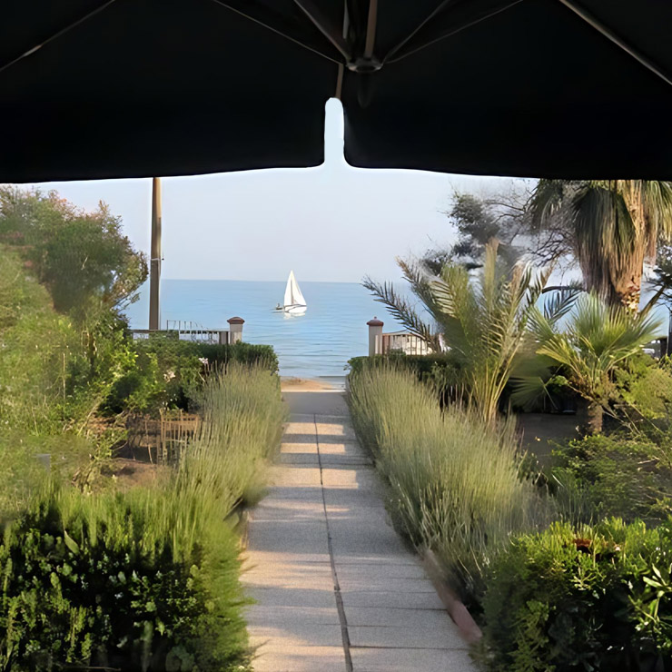 Sicily beach showing the ocean and a sailboat